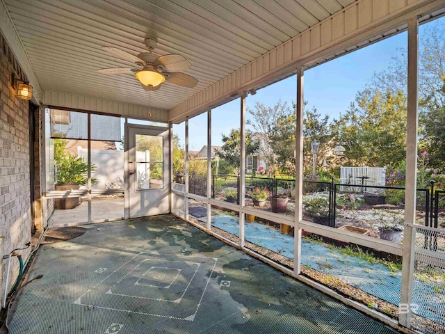 unfurnished sunroom featuring ceiling fan