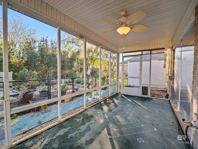 unfurnished sunroom with ceiling fan