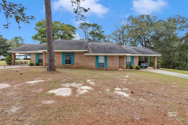 single story home featuring concrete driveway, roof with shingles, a carport, and brick siding