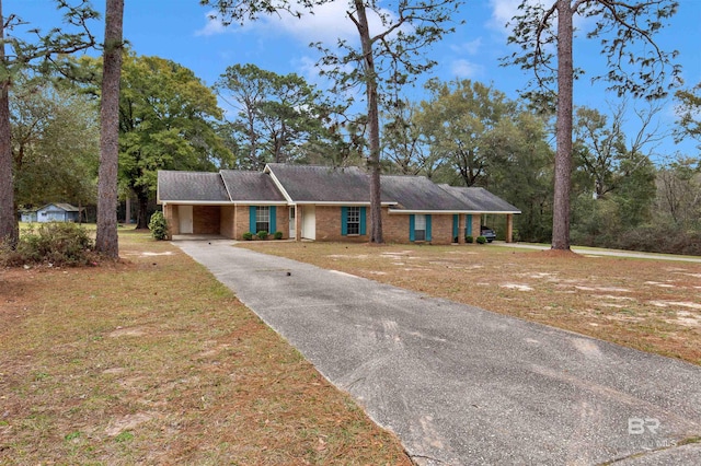 ranch-style house featuring driveway, a carport, a front lawn, and brick siding