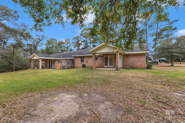 view of front of property with central air condition unit, a front yard, french doors, and brick siding