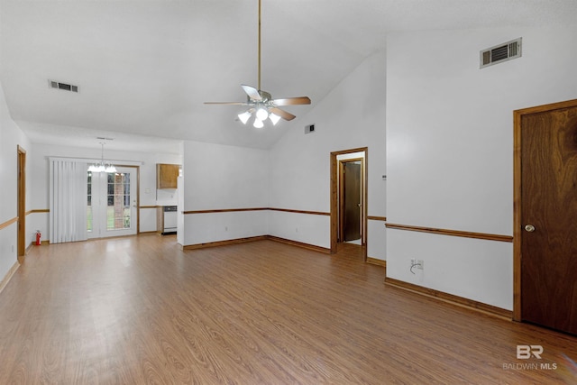 empty room featuring ceiling fan with notable chandelier, light wood-style flooring, and visible vents