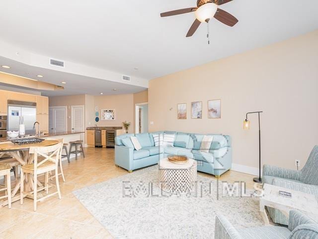 living room featuring sink, ceiling fan, and light tile patterned flooring