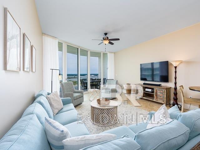 living room with floor to ceiling windows, ceiling fan, and tile patterned flooring