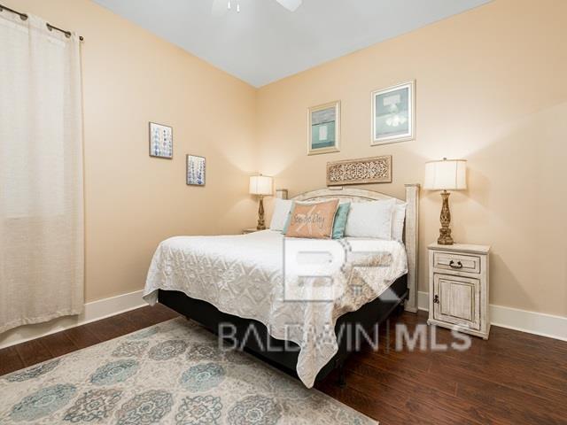 bedroom with ceiling fan and dark wood-type flooring