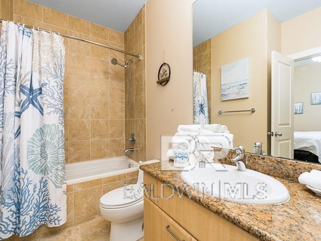 full bathroom featuring shower / bath combo, vanity, and toilet