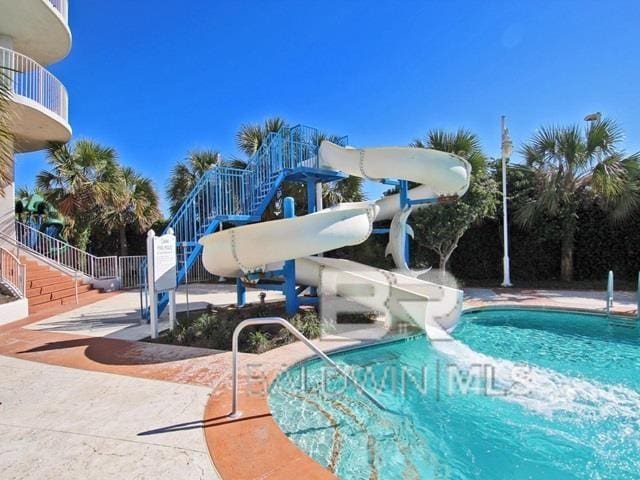 view of pool featuring a patio area and a water slide