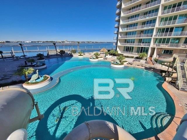 view of swimming pool with a water view