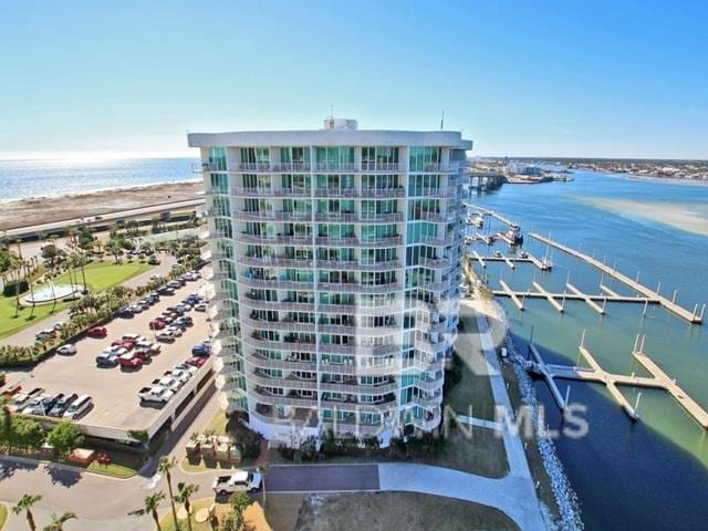 view of building exterior featuring a water view and a beach view