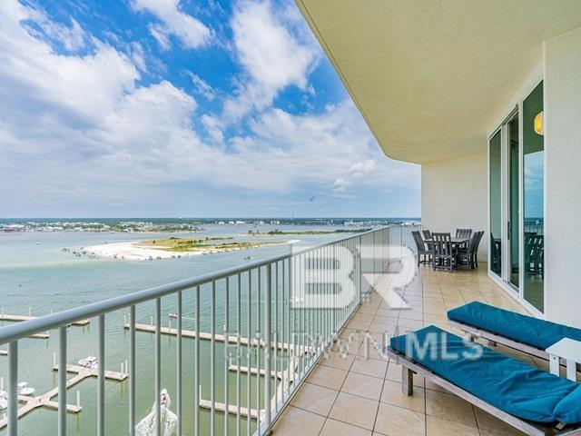 balcony with a water view and a view of the beach