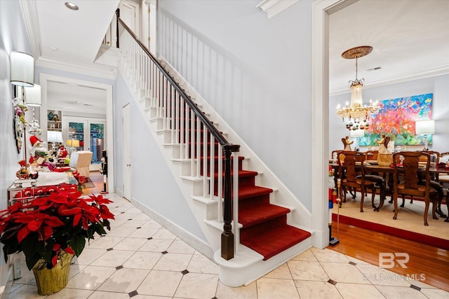 stairs featuring french doors, hardwood / wood-style flooring, an inviting chandelier, and ornamental molding