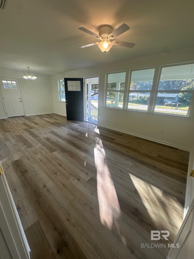 interior space featuring dark hardwood / wood-style floors and ceiling fan with notable chandelier