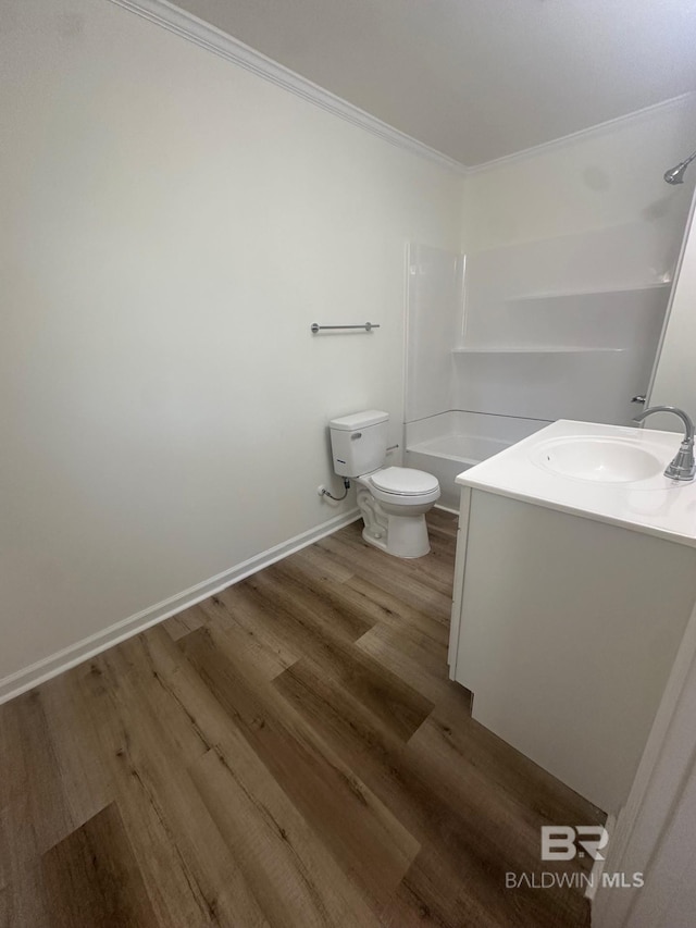 full bathroom featuring toilet, wood-type flooring, shower / bathing tub combination, ornamental molding, and vanity