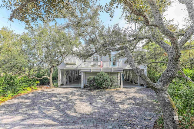 coastal inspired home featuring a carport and decorative driveway