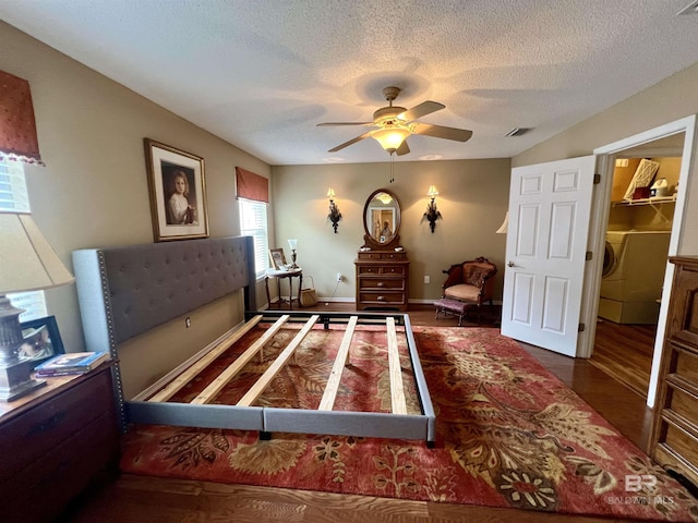 bedroom featuring a spacious closet, ceiling fan, a closet, washer / dryer, and dark wood-type flooring