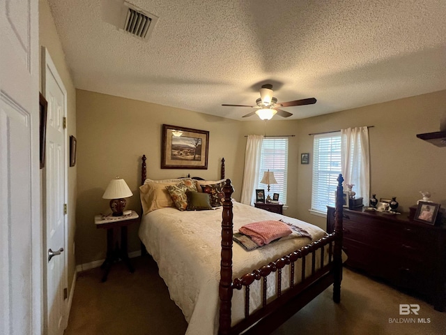 carpeted bedroom with ceiling fan and a textured ceiling