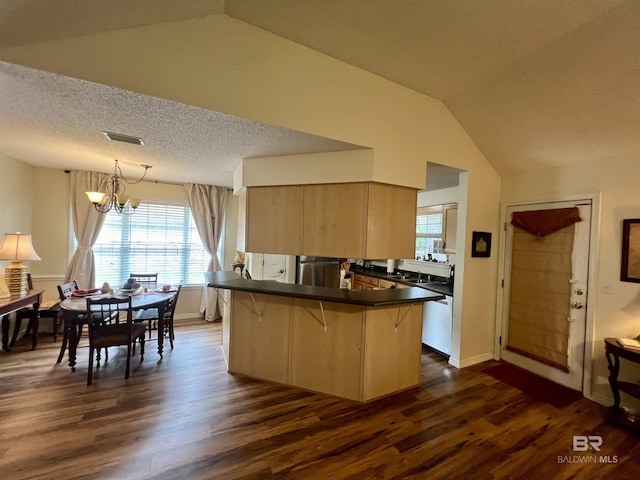 kitchen with kitchen peninsula, decorative light fixtures, a breakfast bar, lofted ceiling, and light brown cabinets