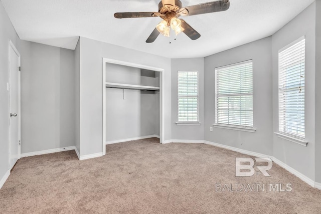 unfurnished bedroom featuring a ceiling fan, carpet, baseboards, and a closet