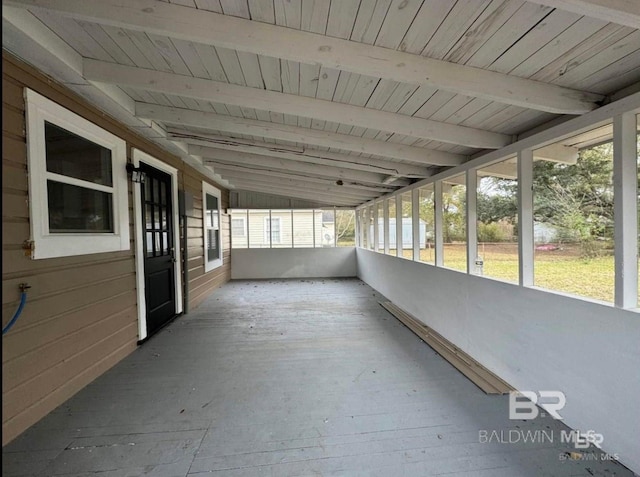 unfurnished sunroom with lofted ceiling with beams