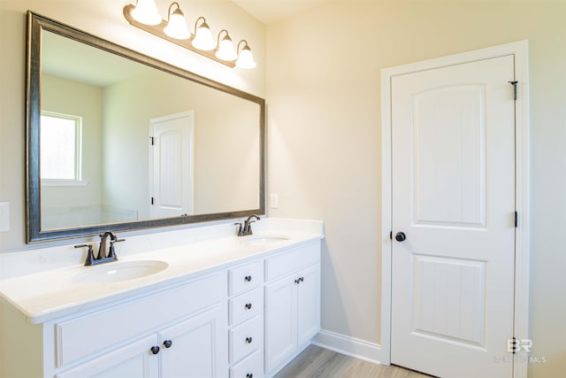 6902 Summerset Dr, Gulf Shores, AL 36542 - bathroom featuring double vanity, baseboards, and wood finished floors