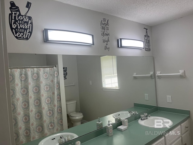 bathroom with vanity, toilet, and a textured ceiling