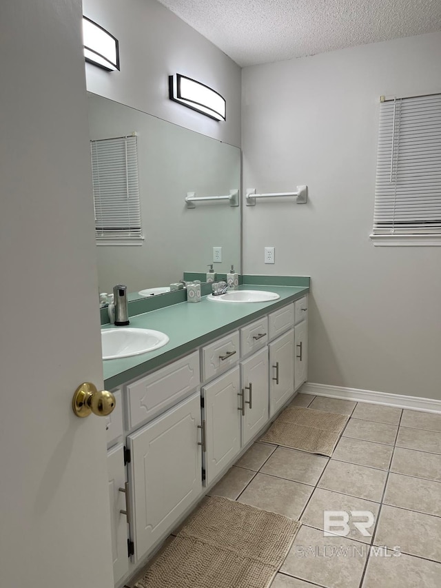 bathroom with tile patterned floors, vanity, and a textured ceiling