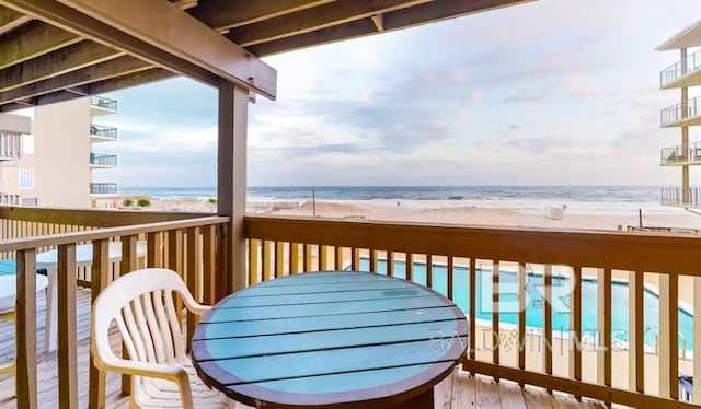 balcony featuring a water view and a beach view