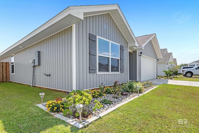 20770 Mercury Dr, Robertsdale, AL 36567 - view of side of home featuring a garage, a yard, board and batten siding, and concrete driveway
