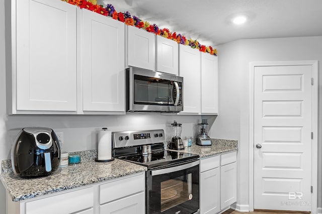 20770 Mercury Dr, Robertsdale, AL 36567 - kitchen with stainless steel appliances, white cabinets, and light stone counters