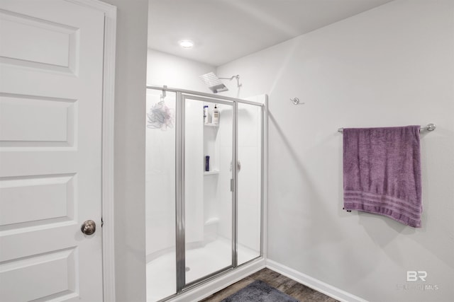 bathroom with hardwood / wood-style flooring and a shower with door