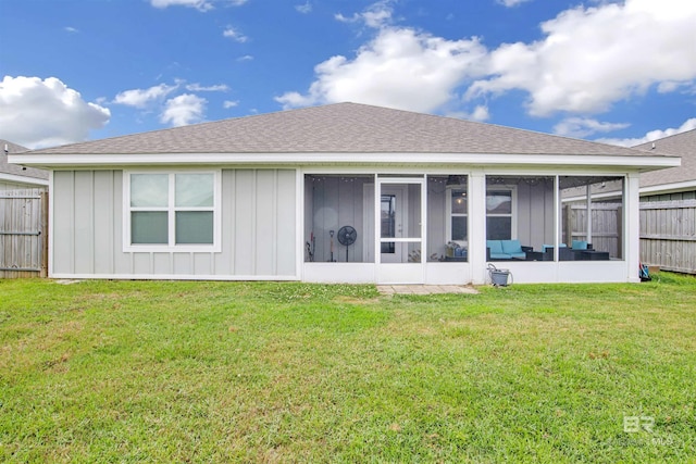 rear view of property featuring a lawn and a sunroom