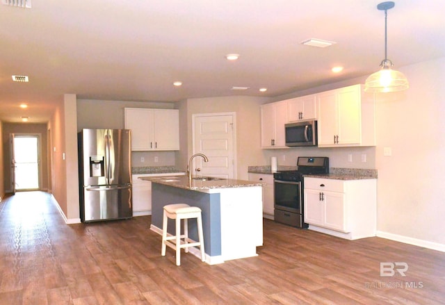 kitchen with a kitchen island with sink, dark wood-type flooring, sink, white cabinetry, and stainless steel appliances