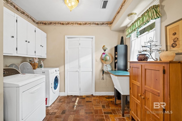 washroom featuring cabinets and washing machine and dryer