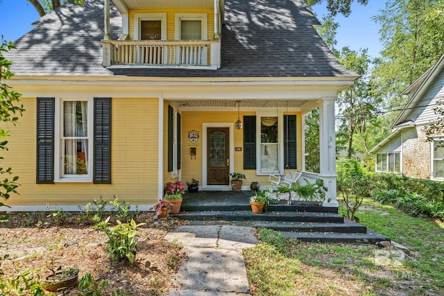 view of front facade with covered porch and a balcony