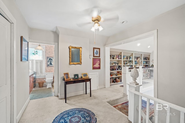 hall featuring built in features and light carpet