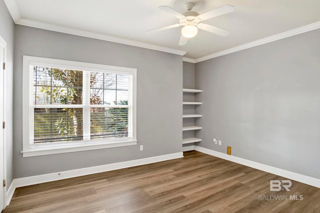 spare room featuring hardwood / wood-style floors, ceiling fan, and crown molding