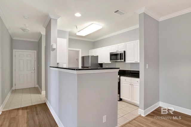 kitchen featuring stainless steel appliances, white cabinets, kitchen peninsula, light tile patterned flooring, and ornamental molding