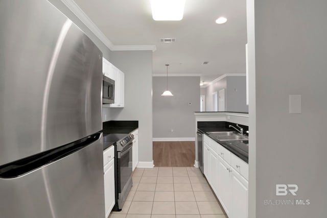 kitchen featuring sink, light tile patterned flooring, stainless steel appliances, and ornamental molding