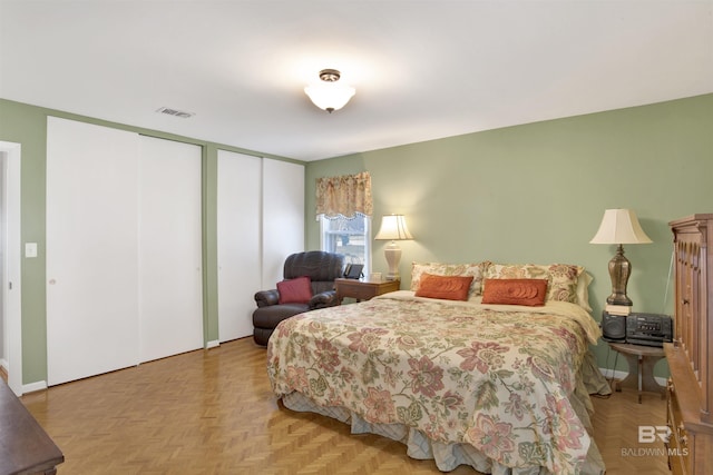 bedroom featuring visible vents and two closets