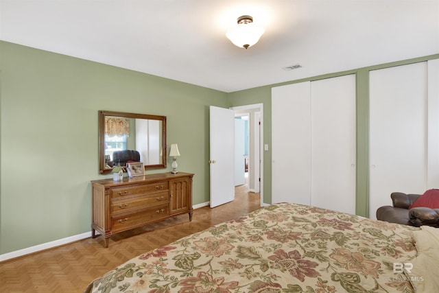 bedroom featuring baseboards, visible vents, and two closets