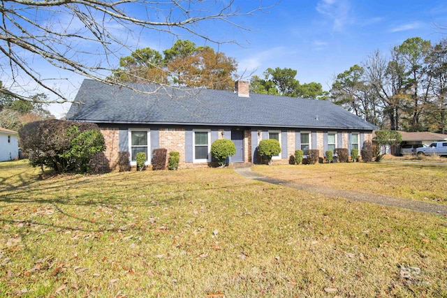 ranch-style house with roof with shingles, a chimney, and a front lawn