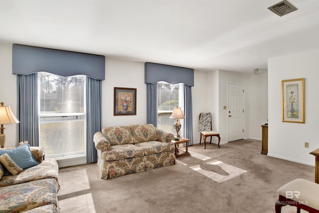 carpeted living area with baseboards and visible vents