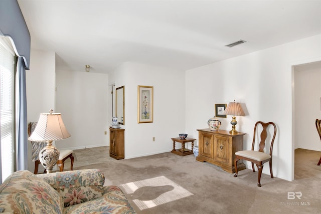 living area featuring light colored carpet and visible vents