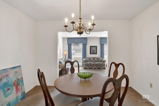 carpeted dining room with baseboards and a chandelier