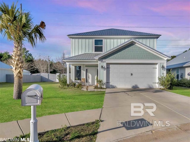 view of front of home featuring a garage, a lawn, concrete driveway, fence, and board and batten siding