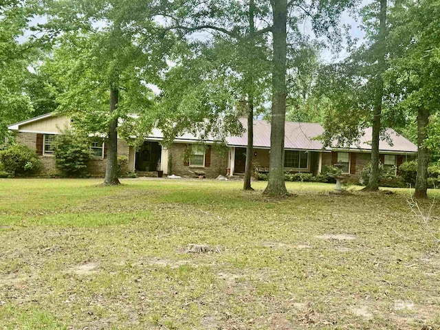 view of front facade featuring brick siding and a front lawn