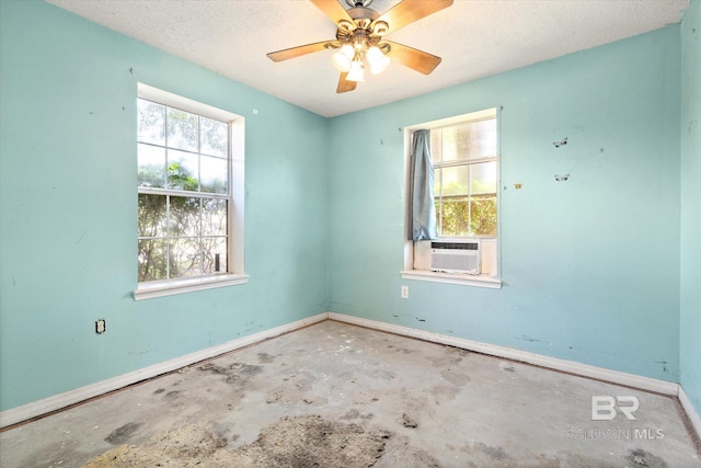 unfurnished room featuring ceiling fan, a textured ceiling, unfinished concrete flooring, baseboards, and cooling unit