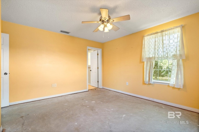 empty room with a ceiling fan, a textured ceiling, visible vents, unfinished concrete floors, and baseboards