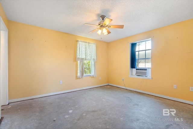 unfurnished room with concrete flooring, baseboards, ceiling fan, a textured ceiling, and cooling unit