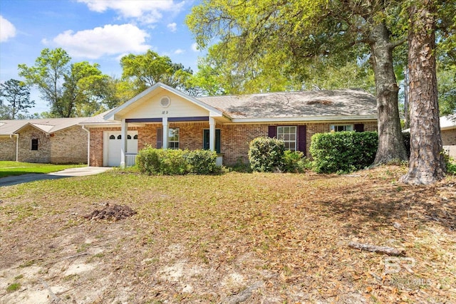 ranch-style house with brick siding, a garage, a front lawn, and aphalt driveway